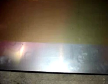 Lackierte Tafel mit einem unlackierten Streifen an einem Ende, verursacht durch eine teilweise überlappende Tafel in der Lackiermaschine