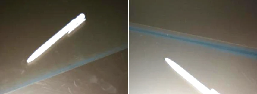 Zwei lackierte Tafeln mit einem unlackierten Streifen am Rand, verursacht durch Lackmangel, mit einem Stift als Größenvergleich